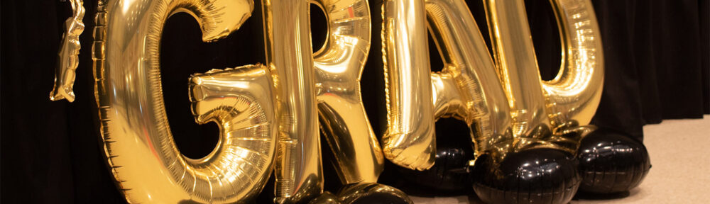 Golden balloons spelling grad, short for graduation or graduate