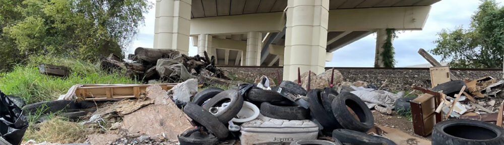 Tires, mattresses and trash under a bridge in Houston, Texas